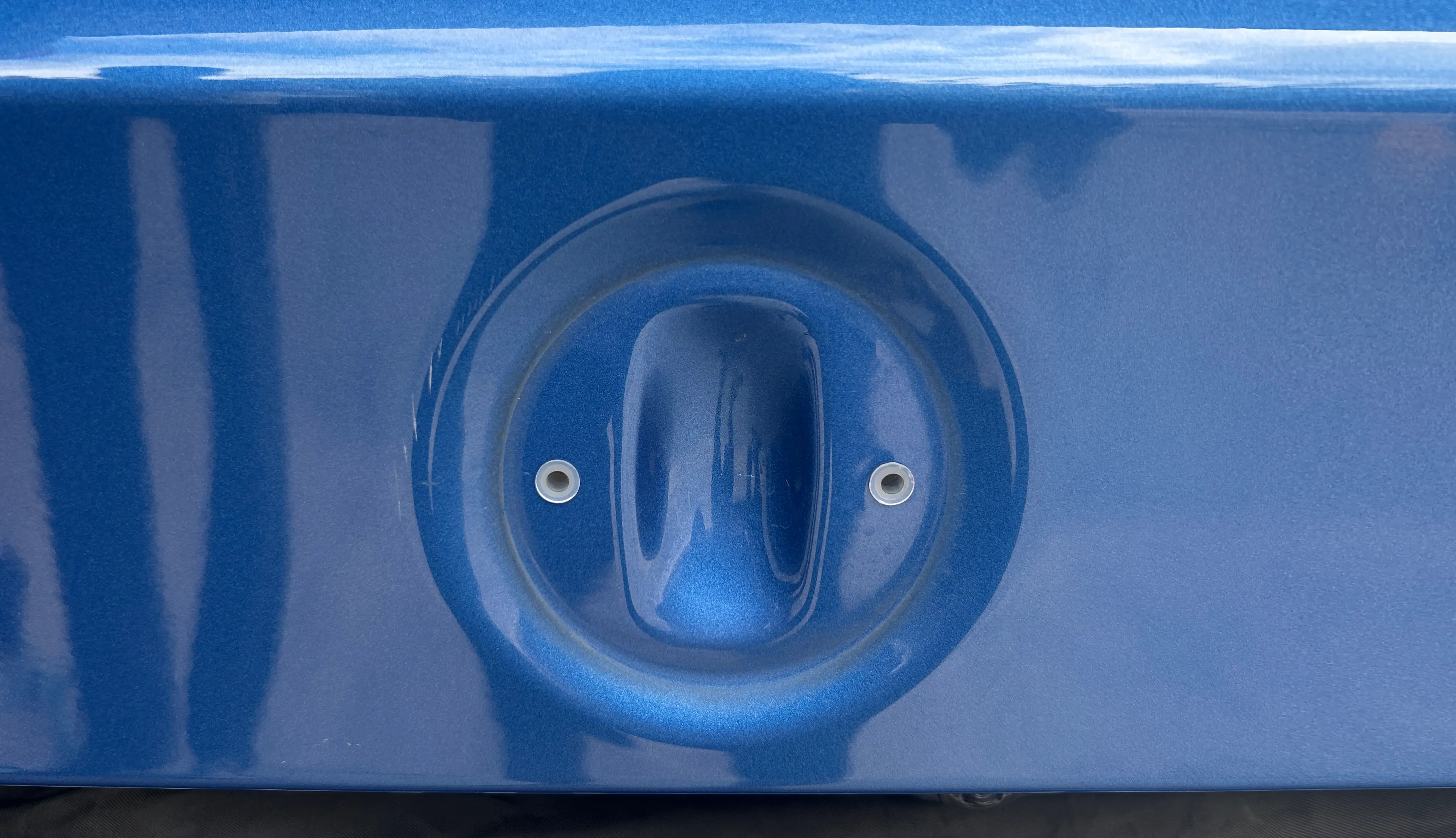 The factory badge recess on a boot lid, with its existing holes and nothing drilled