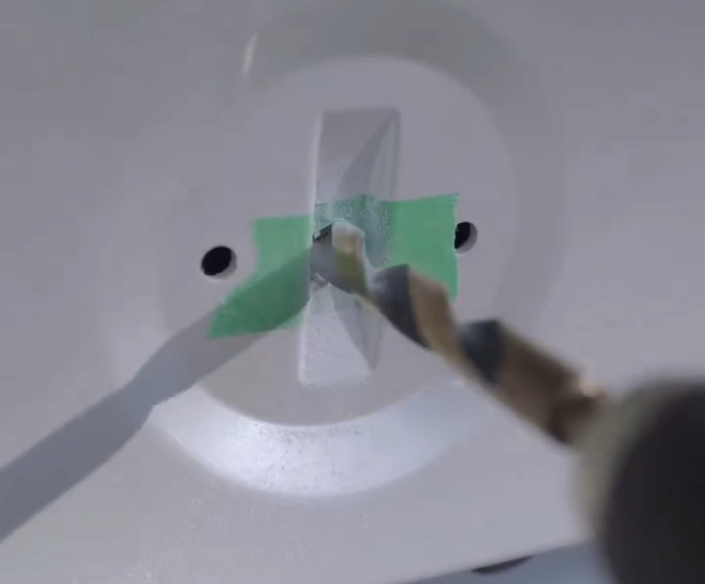 The emblem and its lead being placed into the factory recess by hand